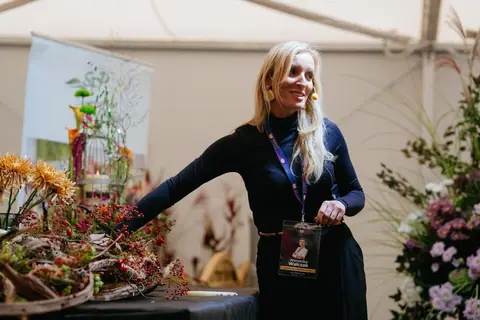 Weronika Walczak, koordynatorka Baltic Flora 2026, przy stole z kompozycjami