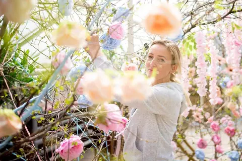 Weronika Walczak wśród zawieszonych róż w tunelu kwiatowym