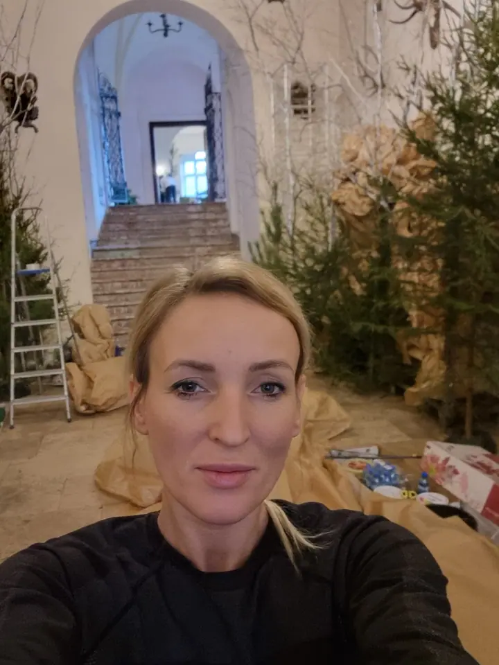 Weronika Walczak przy pracy w sali z choinkami i drabiną, w tle schody