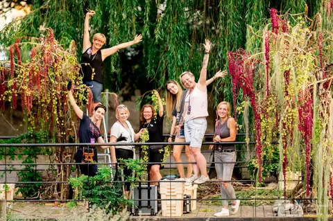 Radosny zespół florystów, wśród nich Weronika Walczak, pomiędzy kaskadami amarantusa
