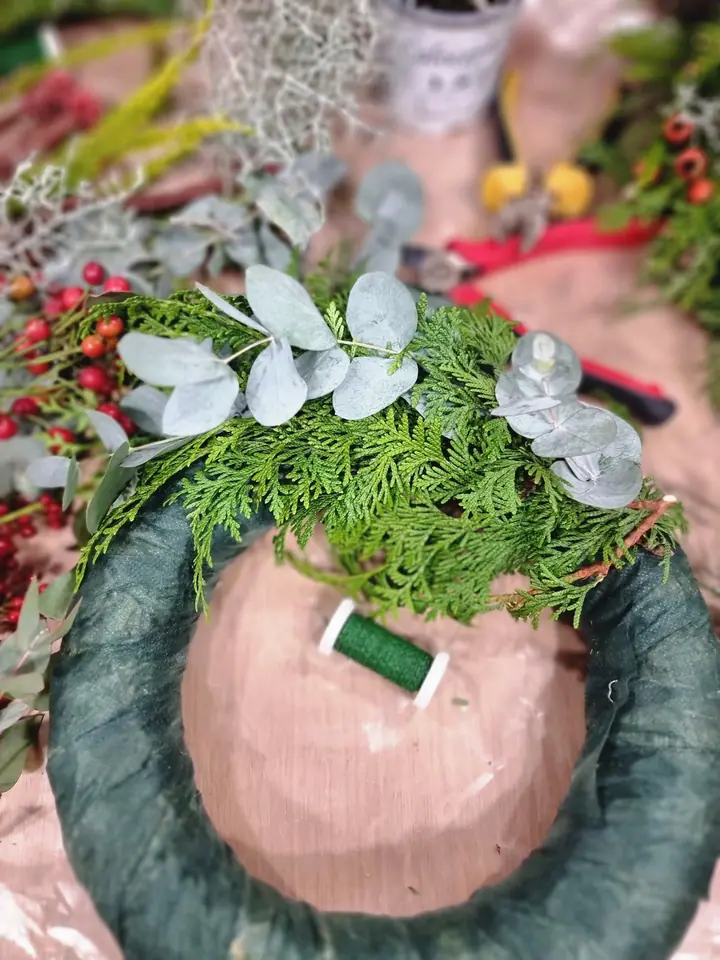Początek pracy — piankowa obręcz wieńca, drut florystyczny, gałązki cyprysika i liście eukaliptusa